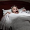 man wakes up from sleep with sleep paralysis scared and confused